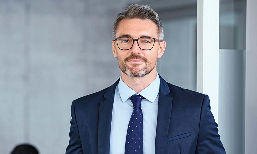 A confident businessman standing with arms crossed, exuding professionalism and determination.